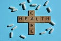 Health care, words and white pills on blue Royalty Free Stock Photo