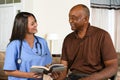 Health Care Worker and Elderly Patient Reading Book Royalty Free Stock Photo