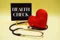 Health Check text message and stethoscope on yellow background Royalty Free Stock Photo