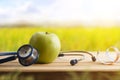 Health concept with apple stethoscope and tape measure in nature Royalty Free Stock Photo