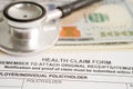 Health claim form with stethoscope and US dollar banknotes, insurance accident medical concept Royalty Free Stock Photo