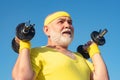 Health club for elderly aged. Senior sport man lifting dumbbells in sport center. Royalty Free Stock Photo