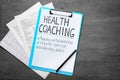 Health coaching written on sheet of paper with medical documents on grey background Royalty Free Stock Photo