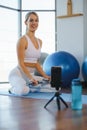 Health-conscious Girl Filming Yoga Workout via Cell Phone.