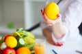 Health. Doctor Dietitian Smiles and Shows Lemon. Woman Holds Fruit in Hands. Young Doctor with a Beautiful Smile at the Light Off