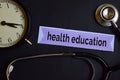 Health Education on the print paper with Healthcare Concept Inspiration. alarm clock, Black stethoscope. Royalty Free Stock Photo