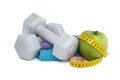 Dumbbells and green apple with tape measure on white Royalty Free Stock Photo