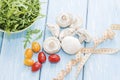 Health food. Fresh mushrooms and arugula salad, cherry tomatoes on light blue background. Diet meals. Royalty Free Stock Photo