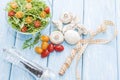 Health food. Fresh mushrooms and arugula salad, cherry tomatoes on light blue background. Diet meals. Royalty Free Stock Photo