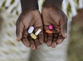 Health and Healthcare: Curing Malaria - African Girl Holding Pills Medicine Health Symbol.