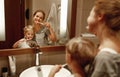 Health and hygiene of oral cavity. mother and child son brush their teeth in bathroom in front of a mirror