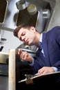 Health Inspector Looking At Oven In Commercial Kitchen