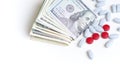 Health insurance, pharmaceutical industry concept. Pills and a wad of cash on white background. Royalty Free Stock Photo