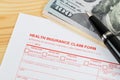 Health insurance claim form with pen on wooden desk