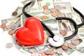 Health insurance concept with red heart, pills and medical instruments on money pile