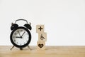 Health and medical icon on wood block and black analog alarm clock on wood desk for health insurance, nonstop medical service