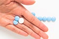 Health and medication concept blue and white pills drug or tablets in woman hand with copy space Royalty Free Stock Photo