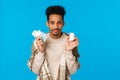 Health, medication and winter season concept. Young african american guy holding drugs and bottle of pills, sneezing Royalty Free Stock Photo