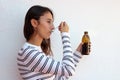 Health and medicine - Young woman taking a cough syrup on a white background Royalty Free Stock Photo