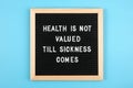 Health is not valued till sickness comes. Motivational quote on black letter board on blue background. Concept Health Care and