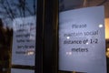 A health notice sign in the front of a store mandating social distancing measures in response to the Coronavirus Royalty Free Stock Photo