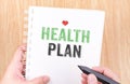 Health plan word on white ring binder notebook with hand holding Royalty Free Stock Photo