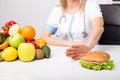 Health professional pushing away burger