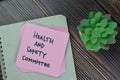 Health and Safety Committee write on sticky notes isolated on Wooden Table