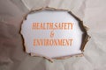 HEALTH, SAFETY AND ENVIRONMENT CONCEPT text at plain torn paper. Royalty Free Stock Photo