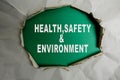 HEALTH, SAFETY AND ENVIRONMENT CONCEPT text at plain torn paper. Royalty Free Stock Photo