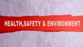 HEALTH, SAFETY AND ENVIRONMENT CONCEPT text at plain torn paper. Royalty Free Stock Photo
