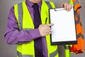 Health and safety instructor in hi viz pointing at a clipboard