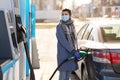 Woman in mask filling her car at gas station Royalty Free Stock Photo