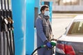 Woman in mask filling her car at gas station Royalty Free Stock Photo