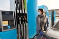 Woman in mask filling car at gas station Royalty Free Stock Photo