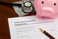 Health savings account, HSA, form with piggy bank, cash money and stethoscope. Royalty Free Stock Photo