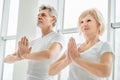 Health and sport concept.Senior couple practicing yoga in the white gym.Health and sport concept. Focus on the man