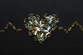 Health support concept. Omega 3, spirulina, chlorophyll, magnesium capsules in heart shape on black dark background. Dietary Royalty Free Stock Photo