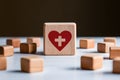 Health symbol wooden block amidst scattered blocks on white surface, signifies medical care importance