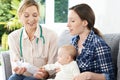 Health Visitor Giving Mother Advice On Feeding Baby With Bottle Royalty Free Stock Photo