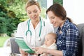 Health Visitor Giving Mother Leaflet With Advice On Baby Royalty Free Stock Photo