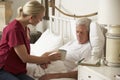 Health Visitor Giving Senior Male Hot Drink In Bed At Home Royalty Free Stock Photo