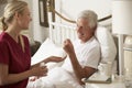 Health Visitor Giving Senior Male Medication In Bed At Home Royalty Free Stock Photo