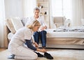 A health visitor putting on slippers on a senior woman at home at Christmas time. Royalty Free Stock Photo