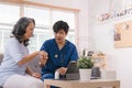 A health visitor is seen with a tablet, explaining to a senior woman how to take her pills. Royalty Free Stock Photo