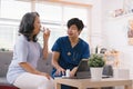 A health visitor is seen with a tablet, explaining to a senior woman how to take her pills. Royalty Free Stock Photo