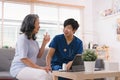 A health visitor is seen with a tablet, explaining to a senior woman how to take her pills. Royalty Free Stock Photo