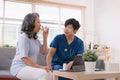 A health visitor is seen with a tablet, explaining to a senior woman how to take her pills. Royalty Free Stock Photo