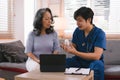 A health visitor is seen with a tablet, explaining to a senior woman how to take her pills. Royalty Free Stock Photo