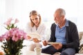 Health visitor and a senior man during home visit. Royalty Free Stock Photo